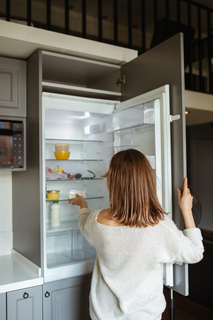 Women adding leftovers to the freezer after doing some gluten-free baking