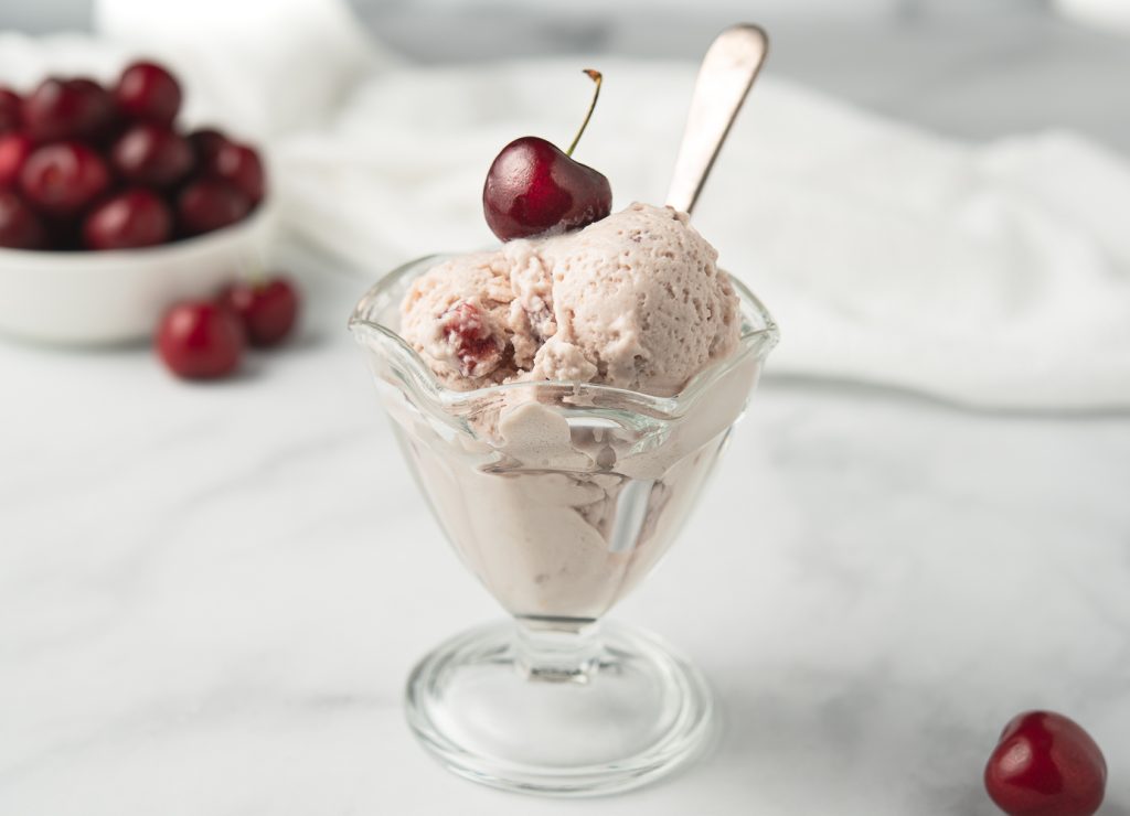 Vanilla Cherry Ice Cream in a Sundae Dish. This dairy free ice cream is the perfect 4th of july dessert