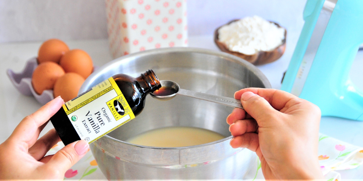 Person pouring a teaspoon of organic vanilla extract