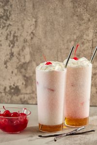 2 vanilla Italian Sodas with whip cream and cherries